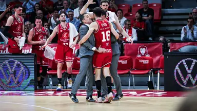 Vives celebra una canasta con su entrenador y el banquillo.